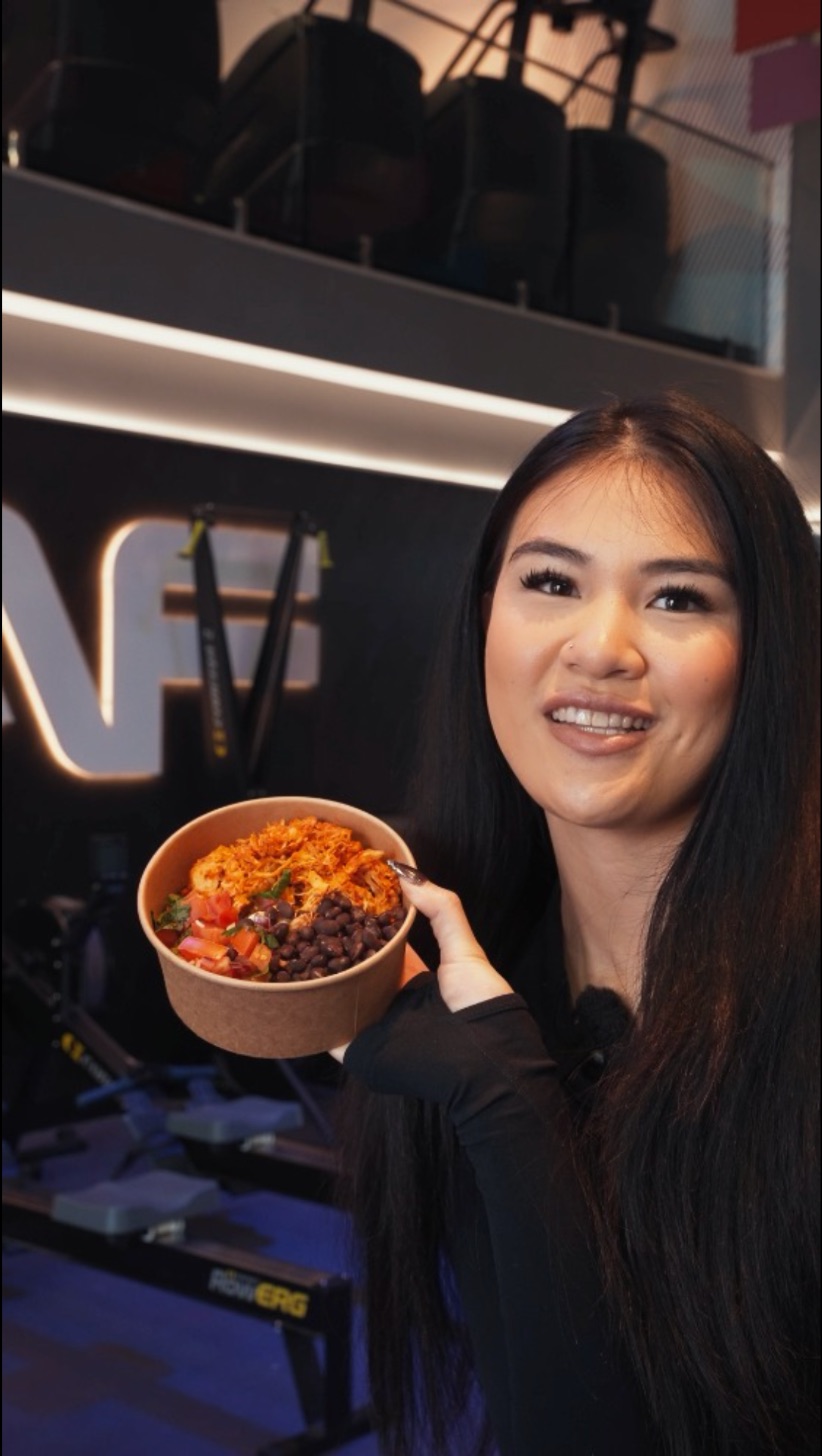 A team member holding a burrito bowl inside Anytime Fitness Fairfield East