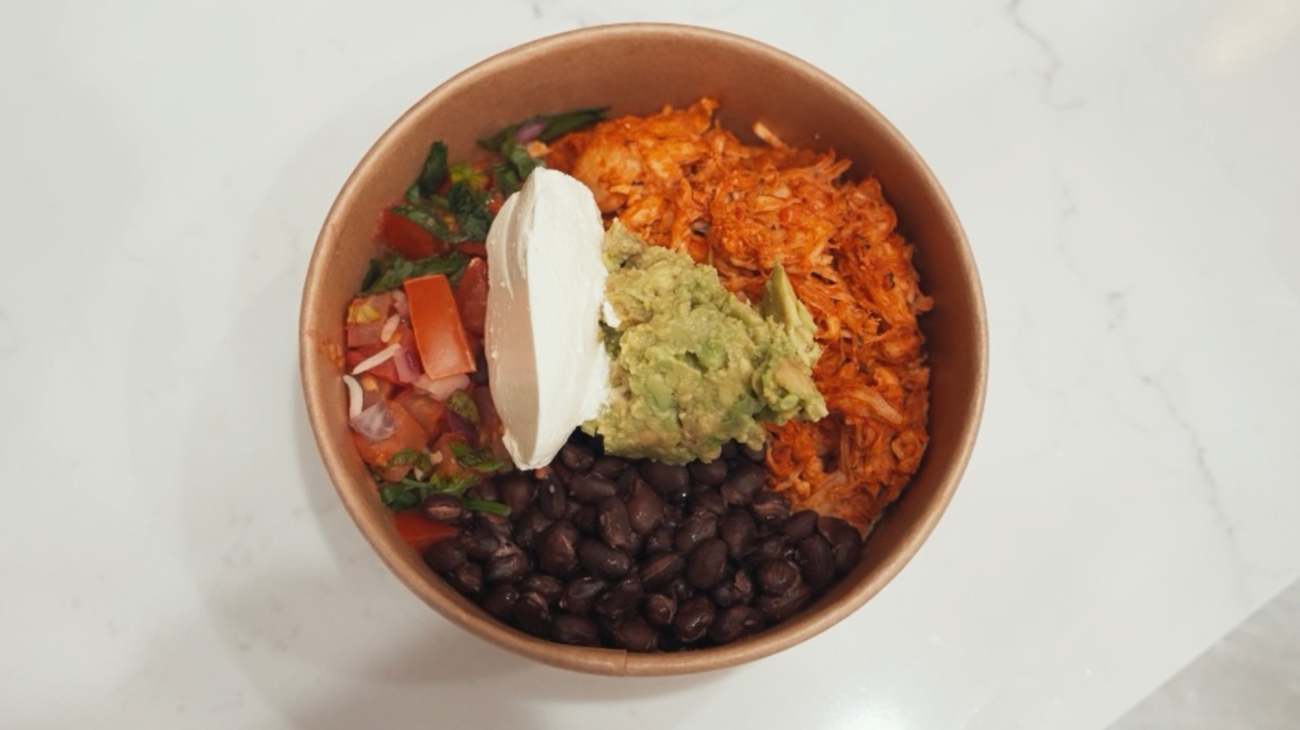 Chicken burrito bowl with black beans, guacamole, salsa and sour cream
